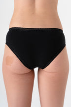 Women's organic cotton lace briefs in black, back view on model