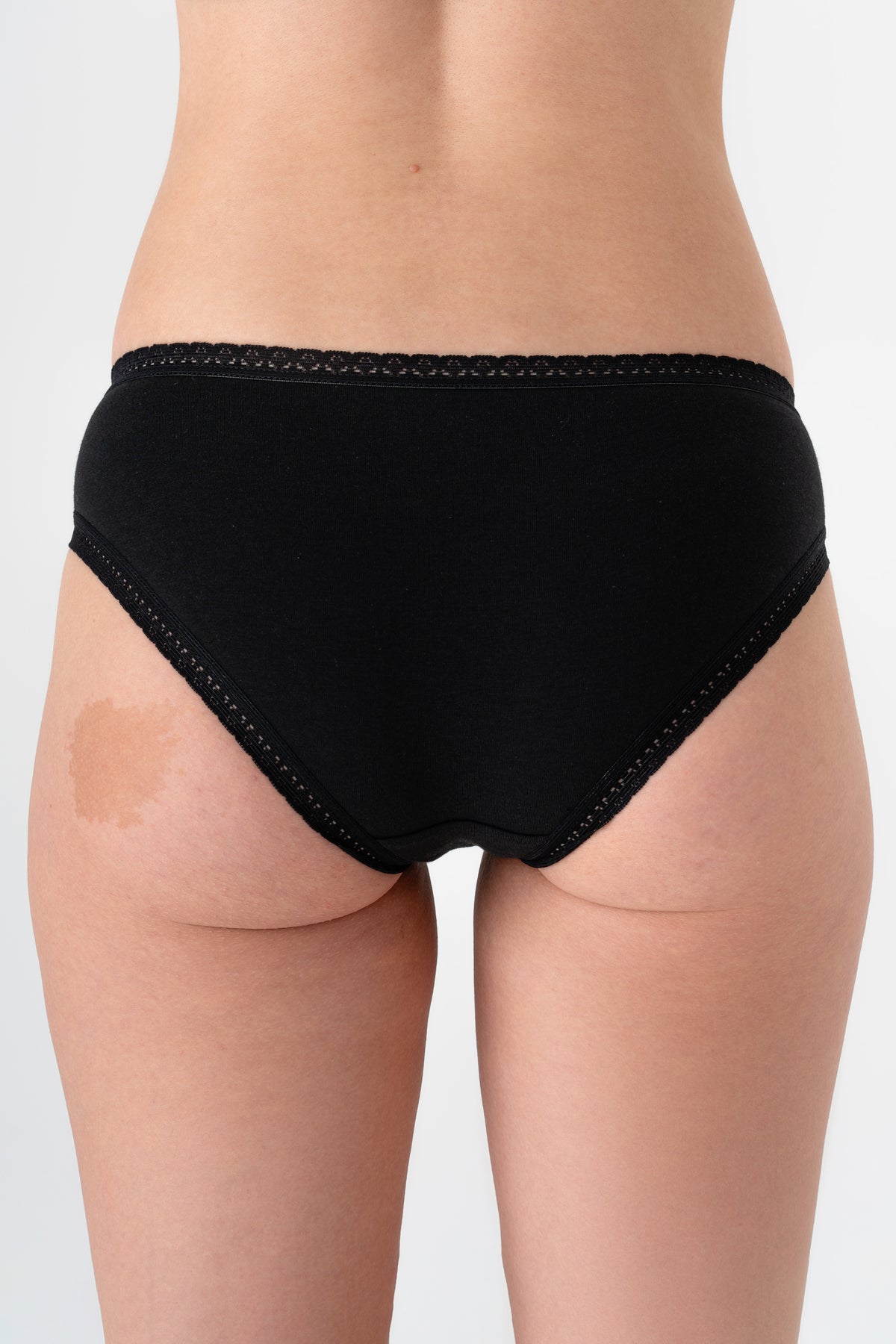 Women's organic cotton lace briefs in black, back view on model