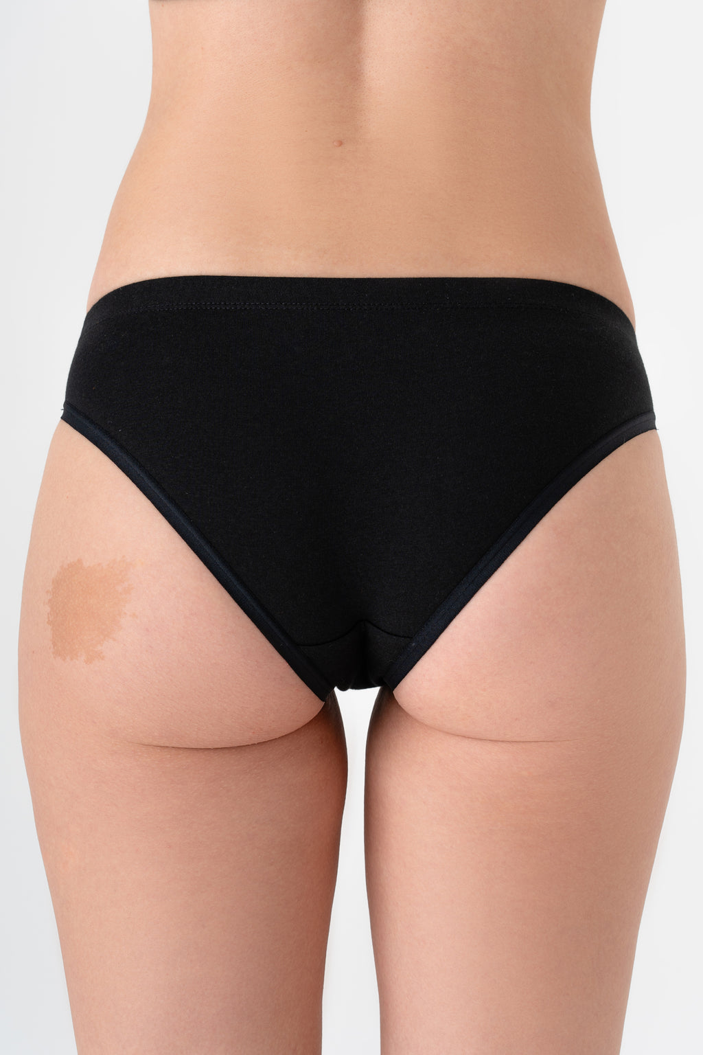Women's organic cotton briefs in black, back view on model