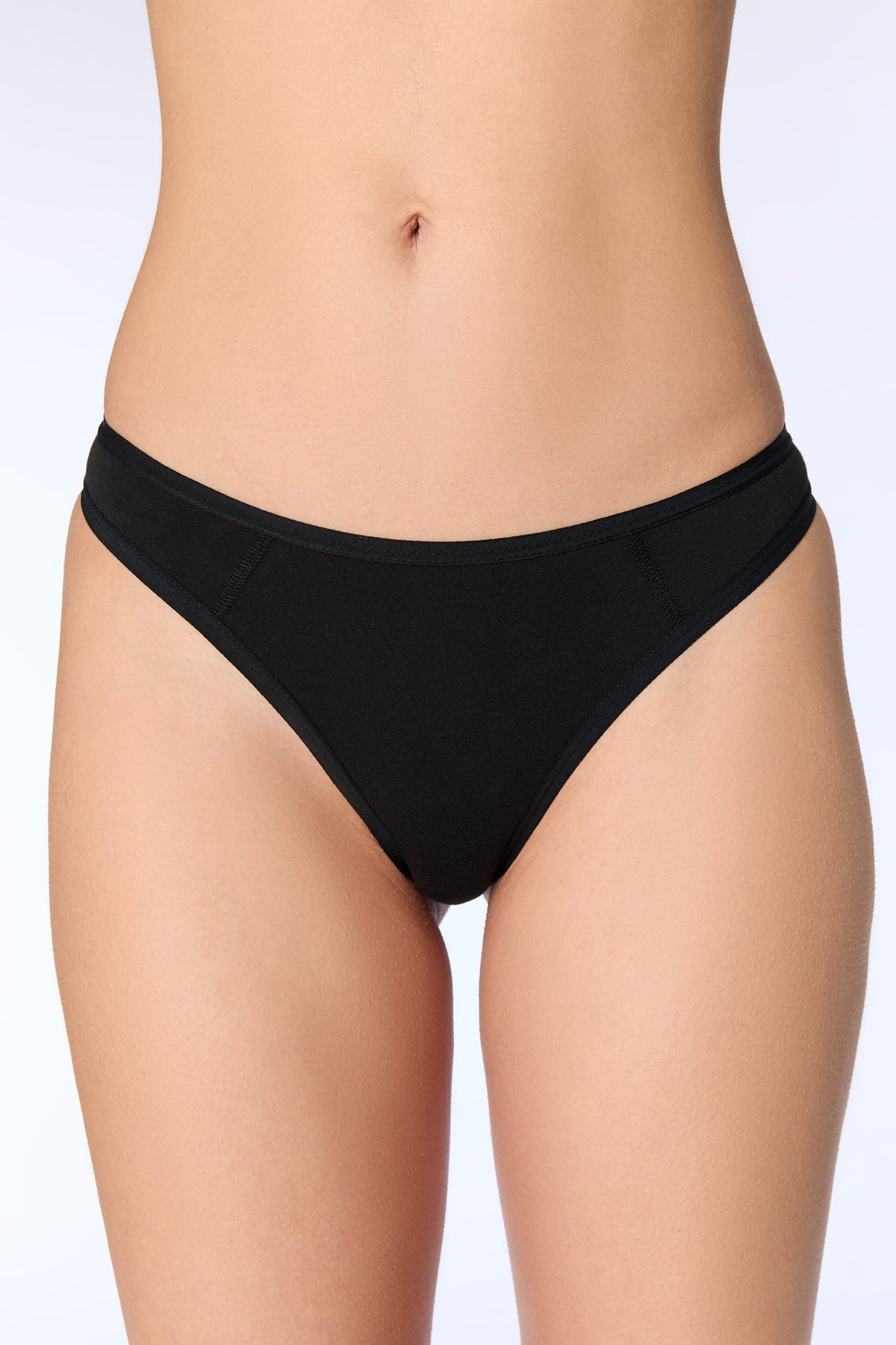 Women's organic cotton thong in black, front view on model
