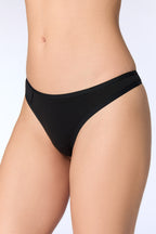 Women's organic cotton thong in black, side view on model