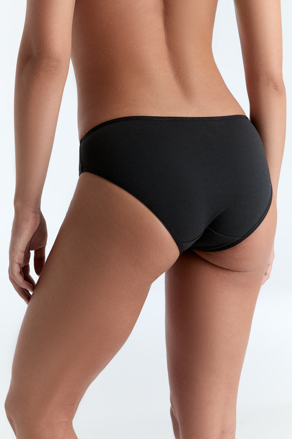 Women's classic organic cotton briefs in black, back three-quarter view on model