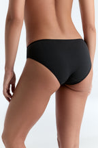 Women's classic organic cotton briefs in black, back three-quarter view on model