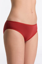 Women's classic organic cotton briefs in red, side view on model