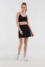 Women's organic cotton bralette in black, full-length view on model, styled with a skirt