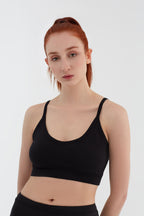 Women's organic cotton bralette in black, front view on model
