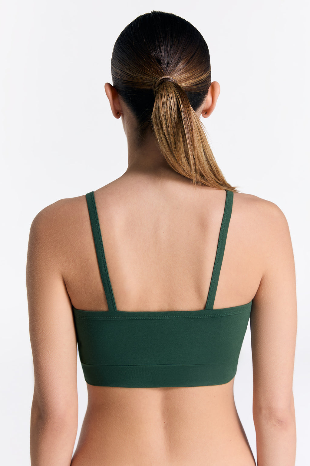 Women's organic cotton bralette in Dark Green, back view on model