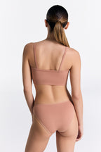 Women's organic cotton bralette in Café Crema, worn with matching classic briefs, back view