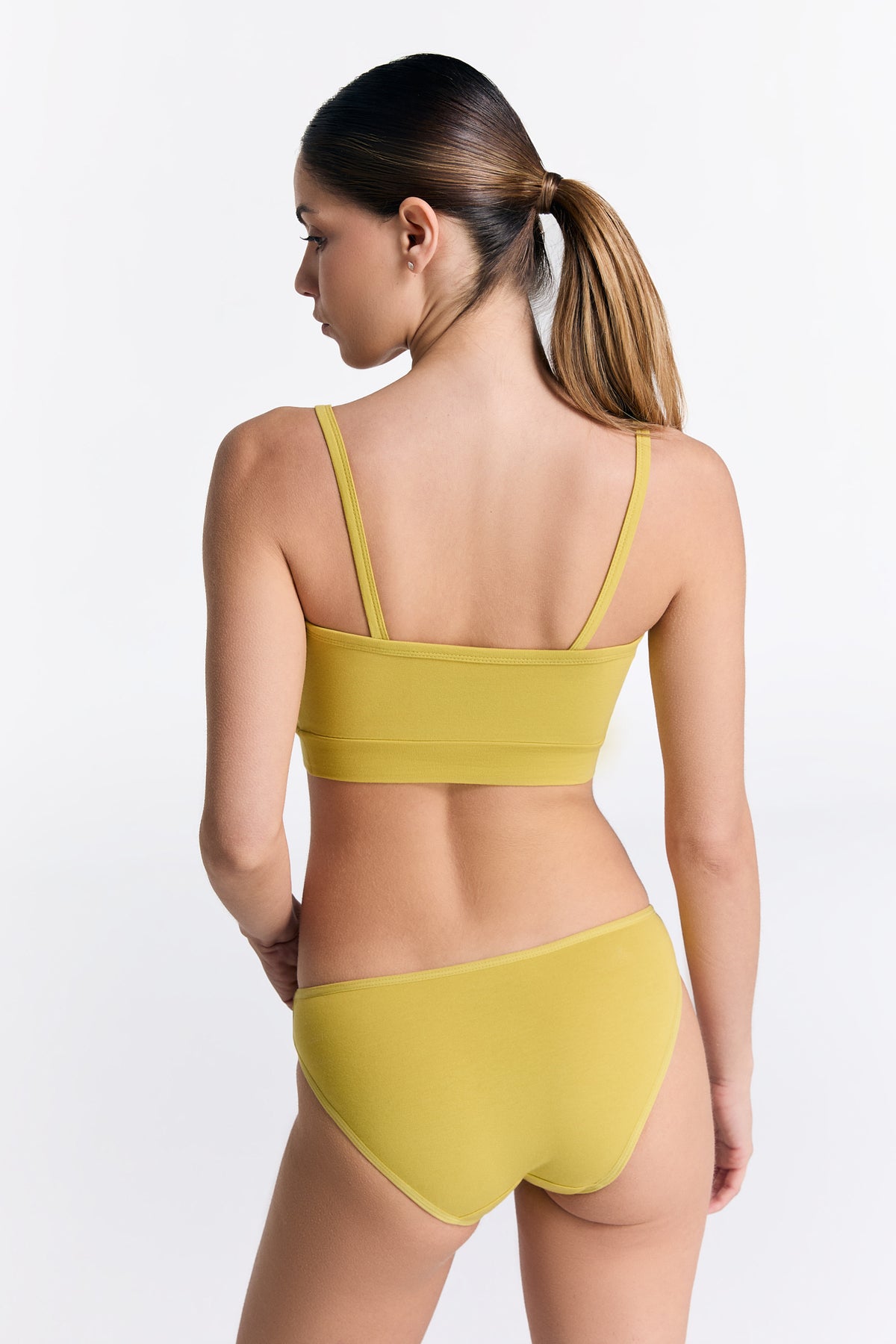 Women's organic cotton bralette in lime, worn with matching classic briefs, back view