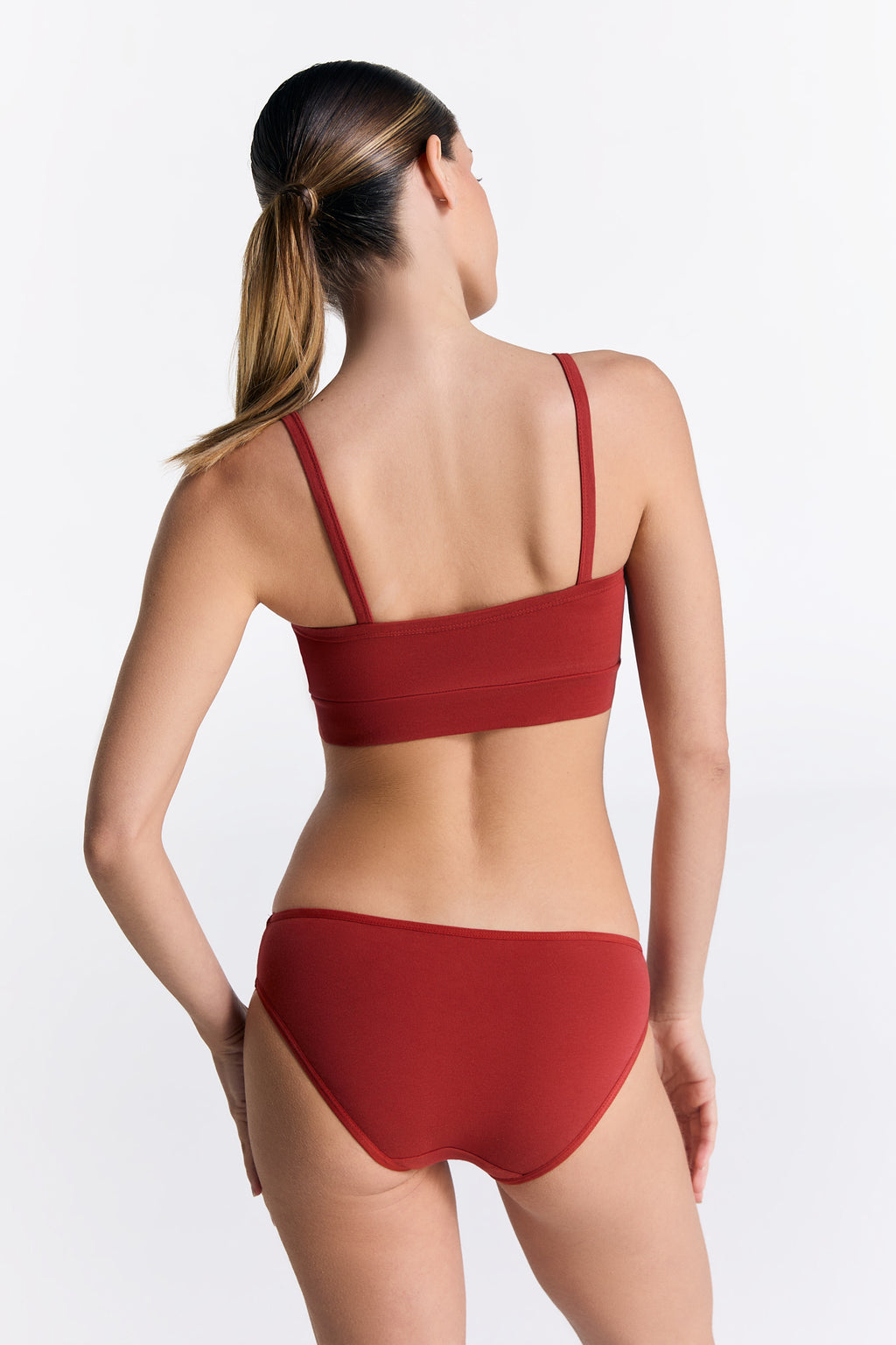 Women's organic cotton bralette in red, worn with matching classic briefs, back view