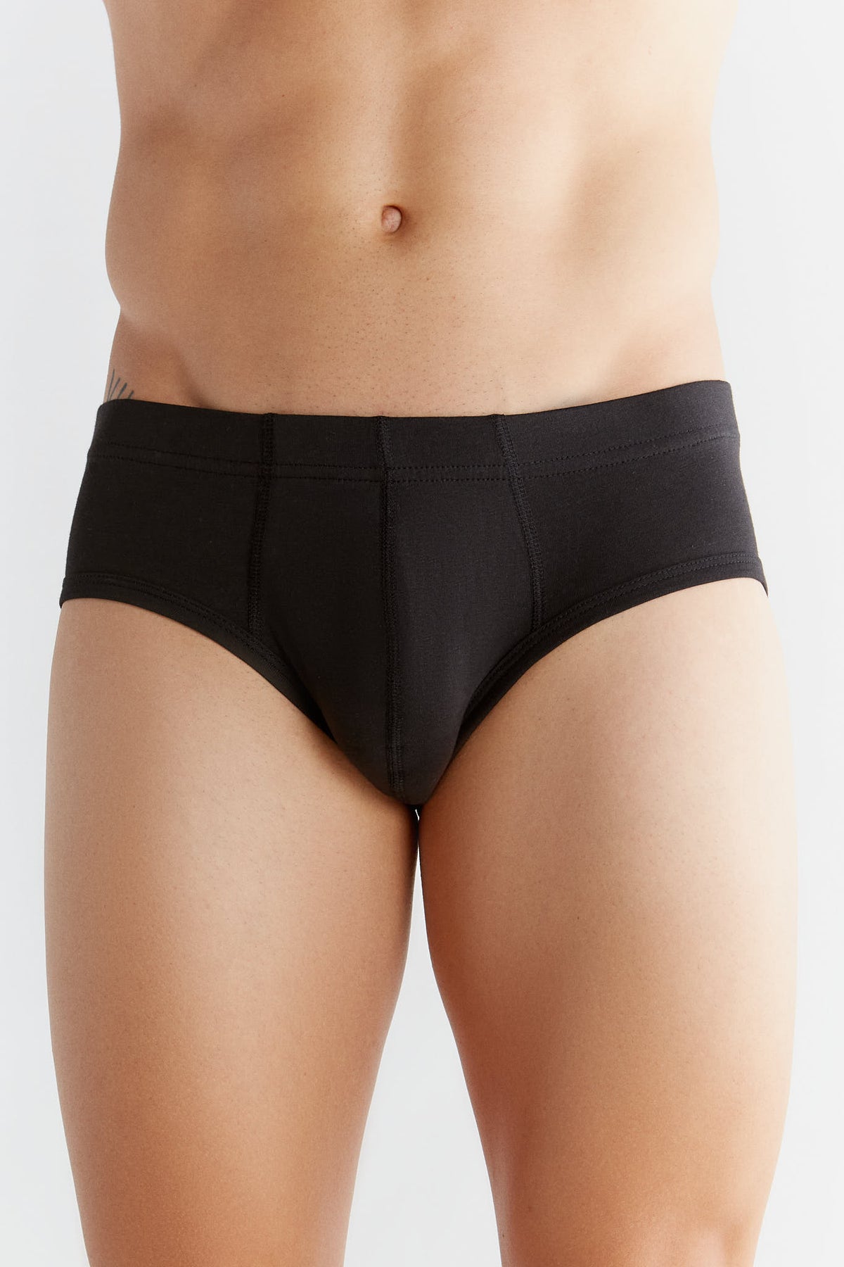 Men's organic cotton briefs in black, front view on model