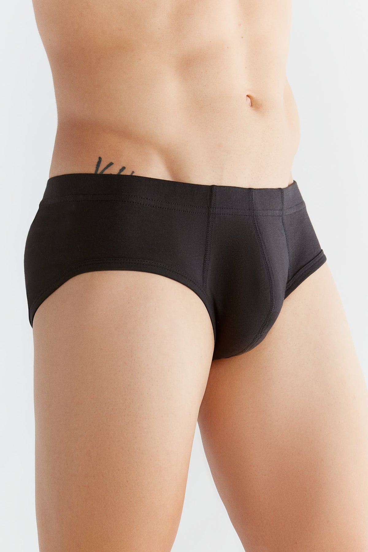 Men's organic cotton briefs in black, side view on model