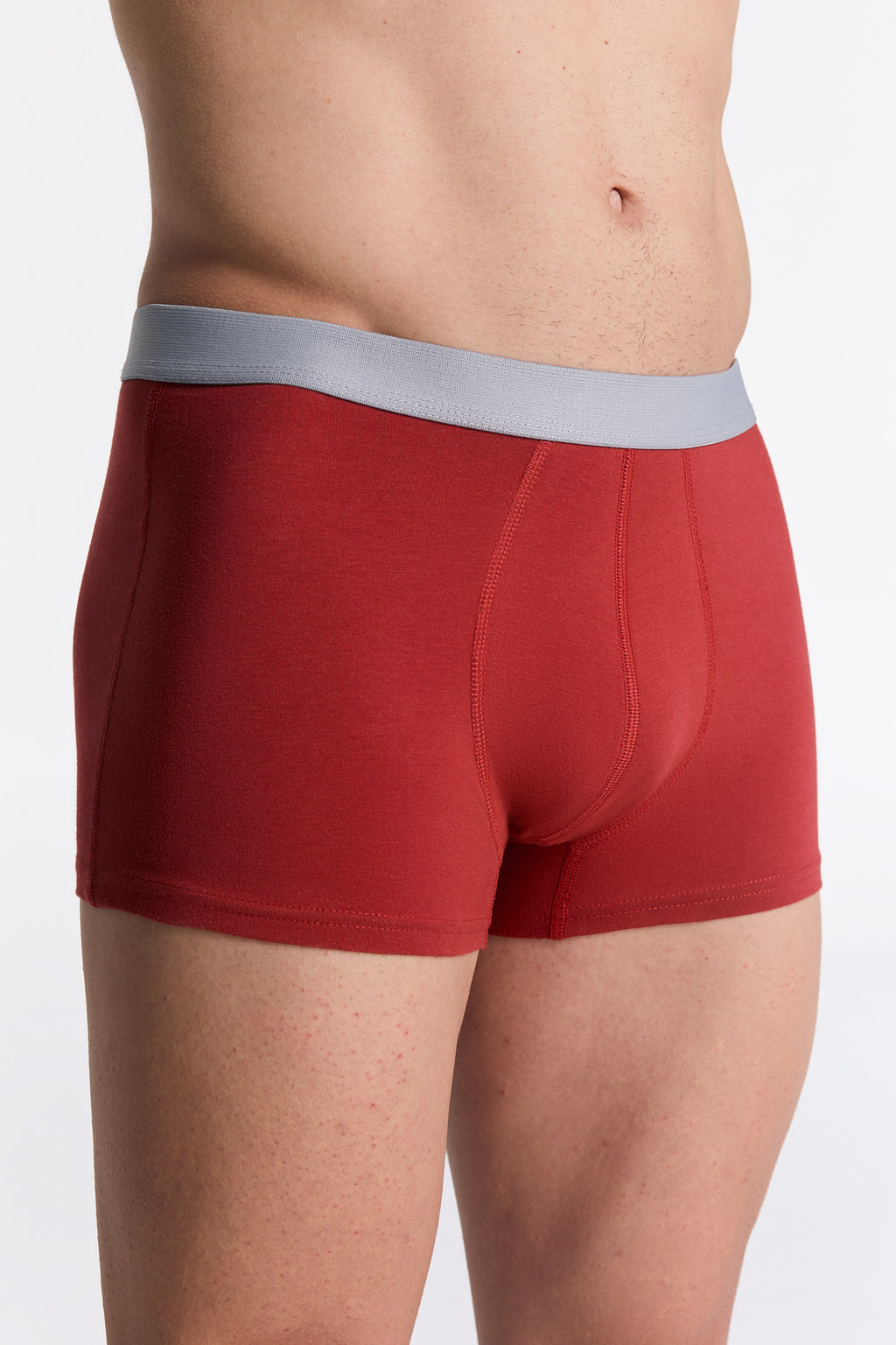 Men's organic cotton trunks in red, side view on model