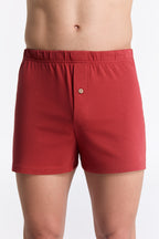 Men's organic cotton boxer shorts in red, front view on model