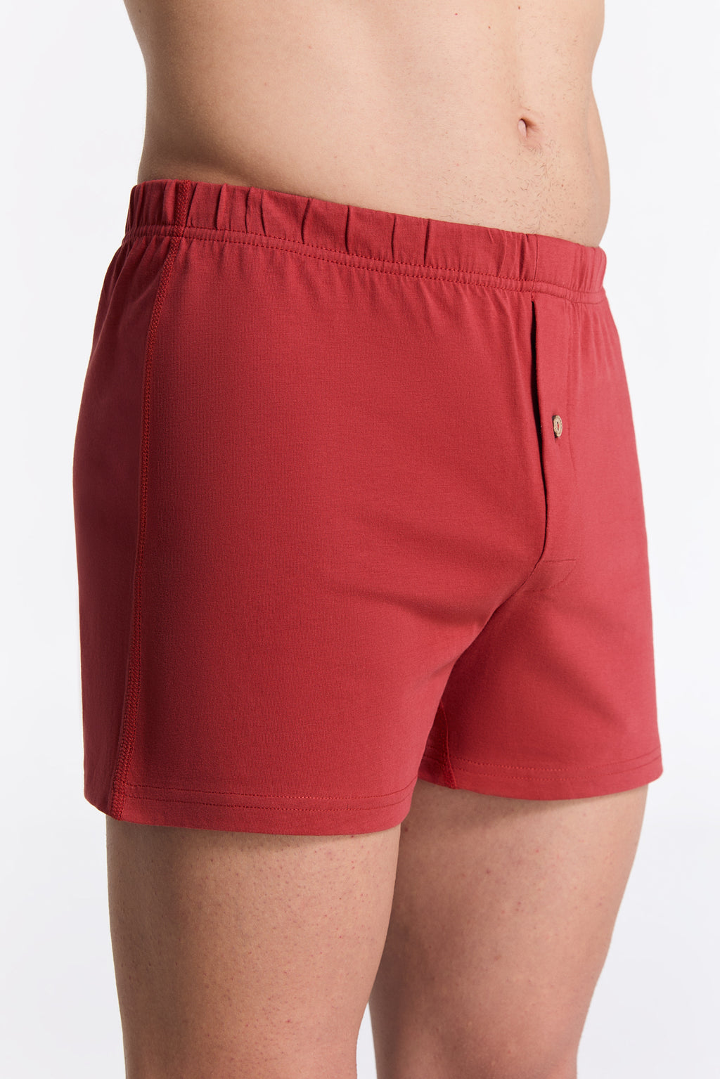 Men's organic cotton boxer shorts in red, side view on model