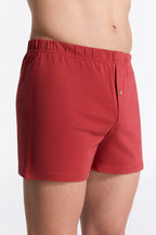 Men's organic cotton boxer shorts in red, side view on model