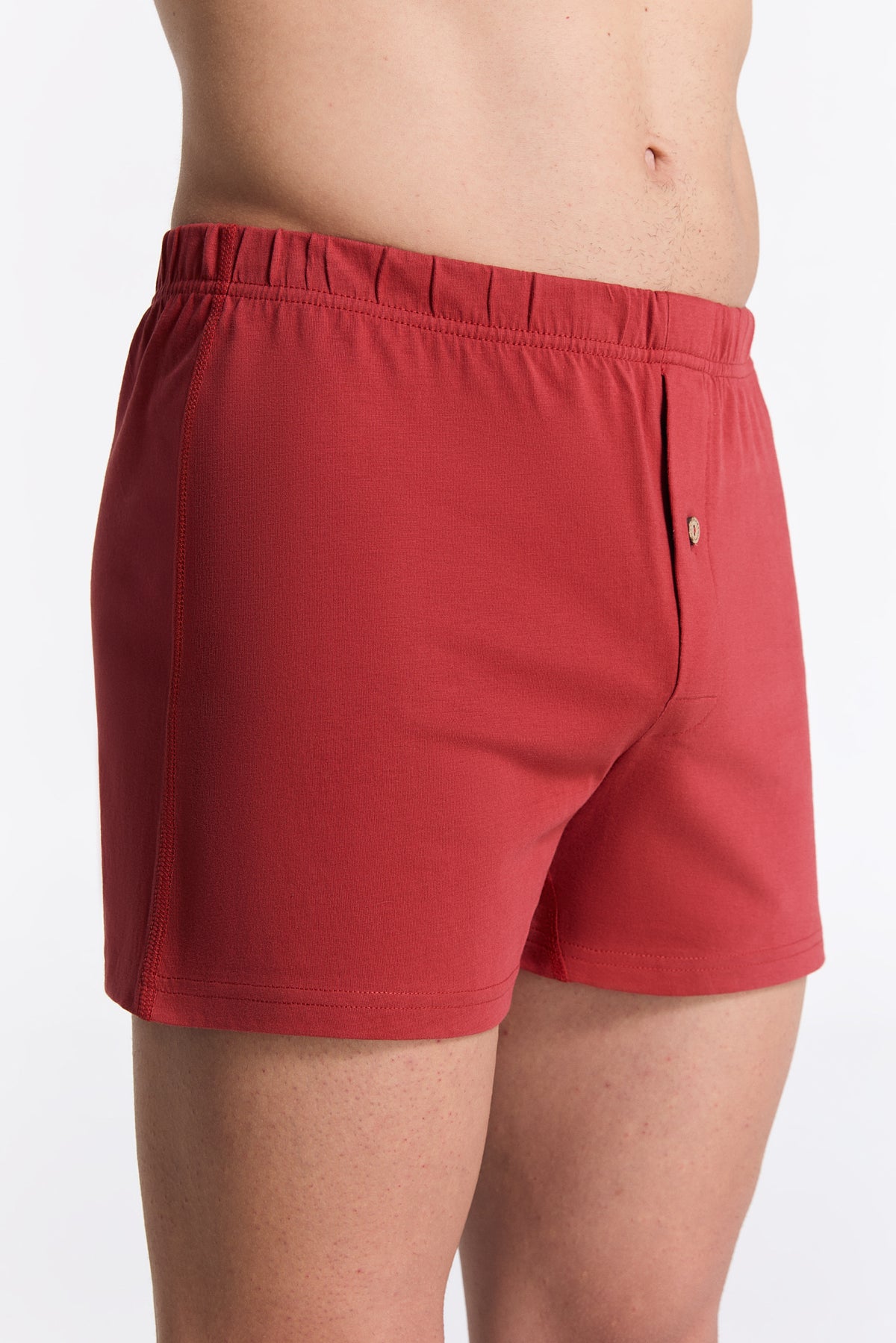 Men's organic cotton boxer shorts in red, side view on model