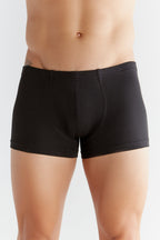 Men's organic cotton boxer briefs in black, front view on model