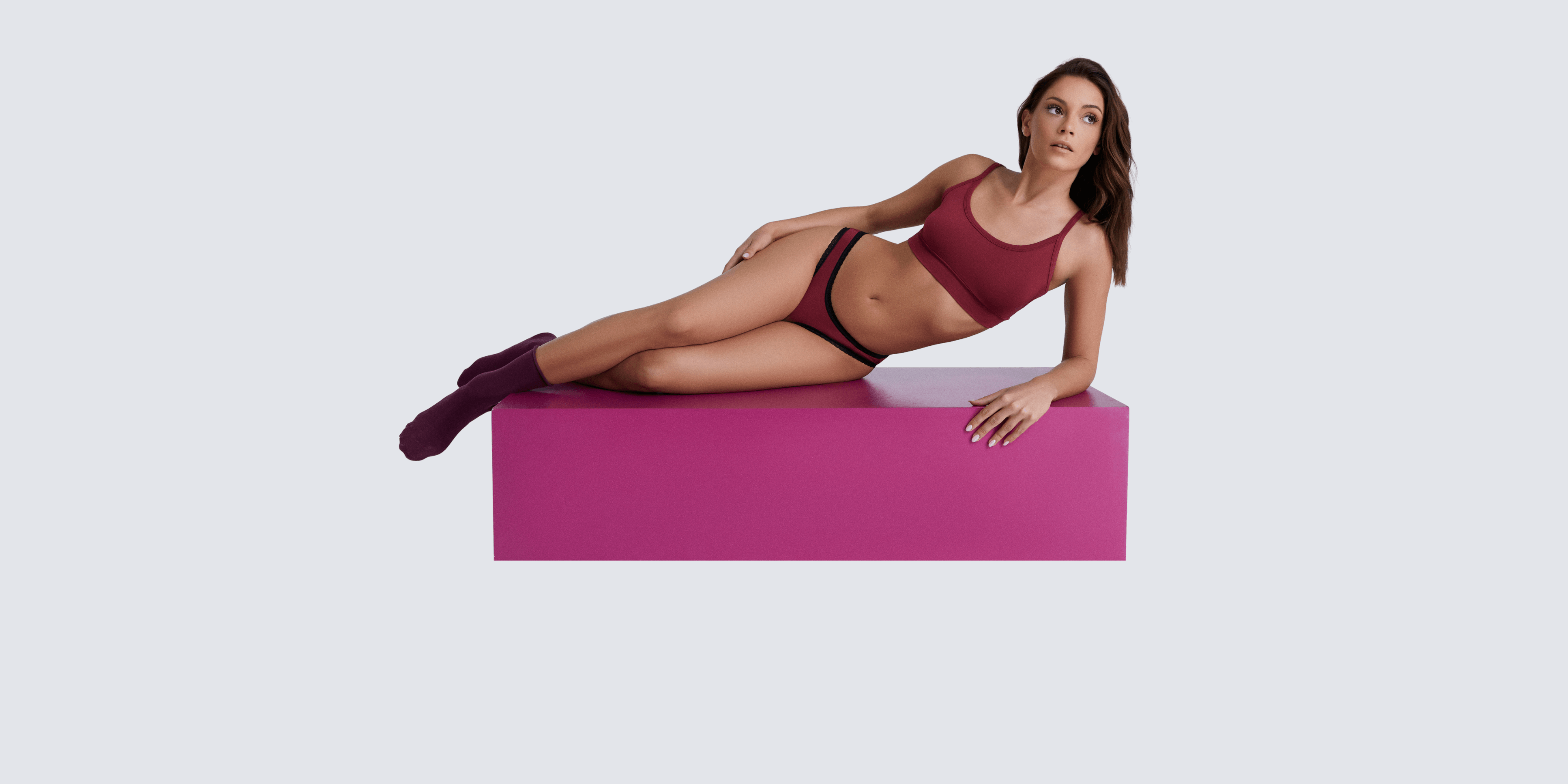 Model wearing a burgundy bralette and matching underwear.